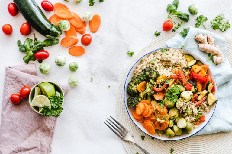 A healthy meal sitting on a table surrounded by vegetables.