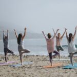 A group of people doing yoga on a beach