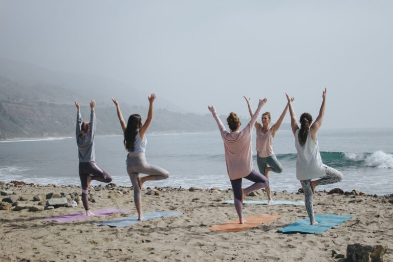 A group of people doing yoga on a beach