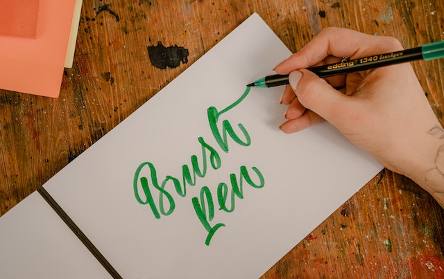 Font designer writing in cursive with brush pen