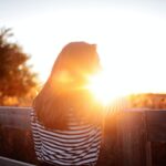 rear view of woman standing in balcony during sunset