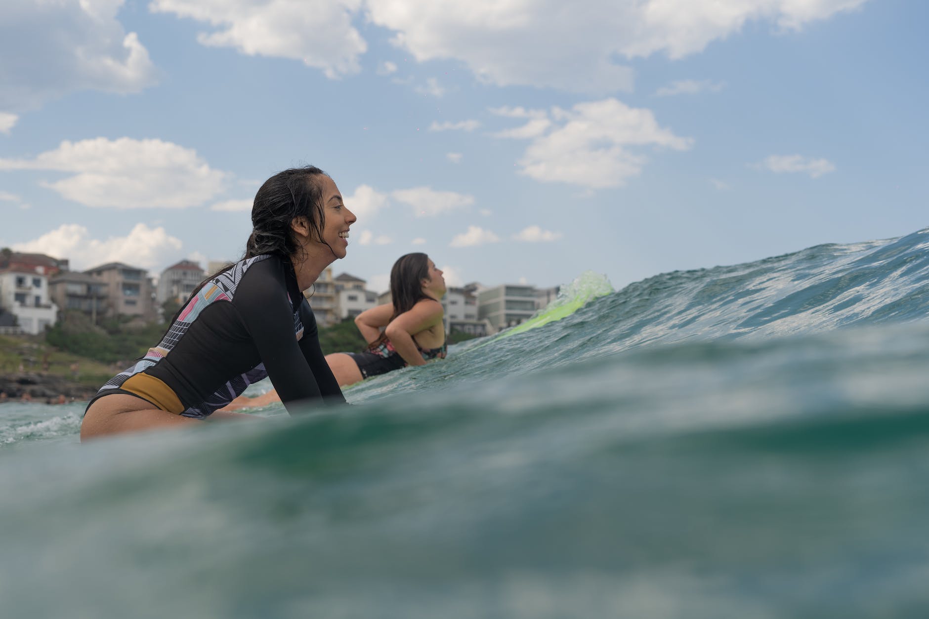 photo of women riding surfboard