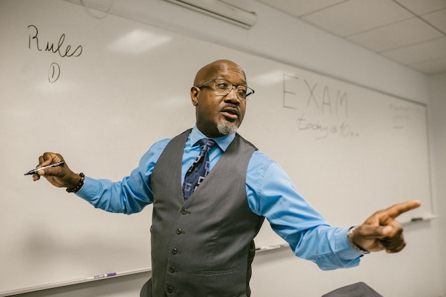 A teacher writing on a whiteboard