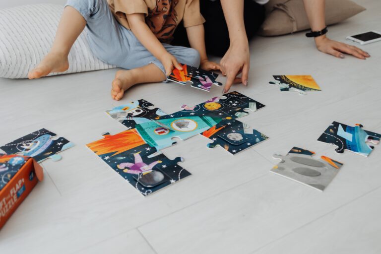 Kids sitting on the floor putting a puzzle together.