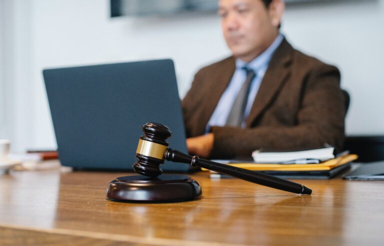 Lawyer sitting at a desk with a gavel in front of him.