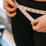 A person measuring their waist line to see if they lost weight