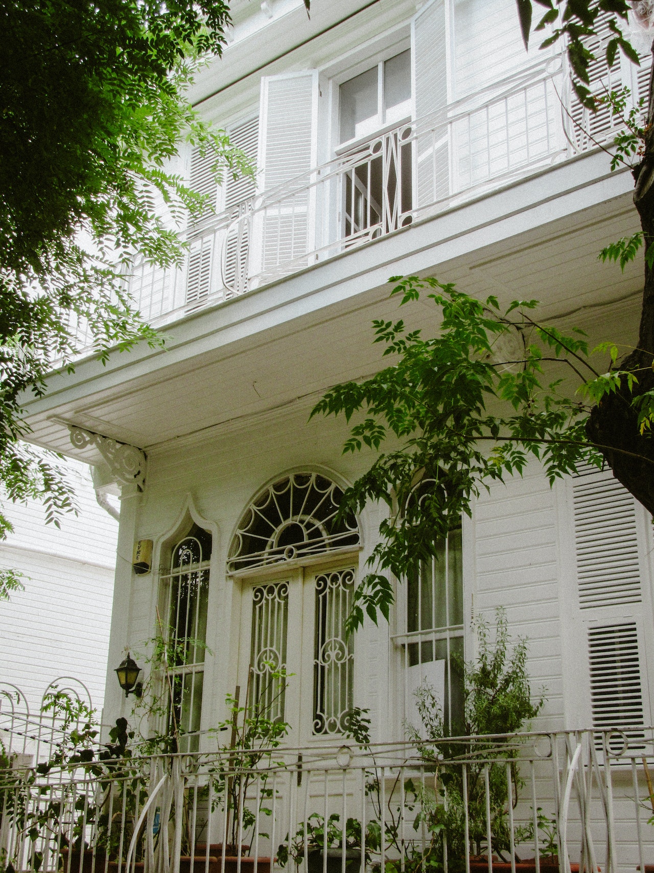 An elegant-looking home with a balcony, pictured from below