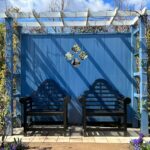 wooden chairs under blue pergola