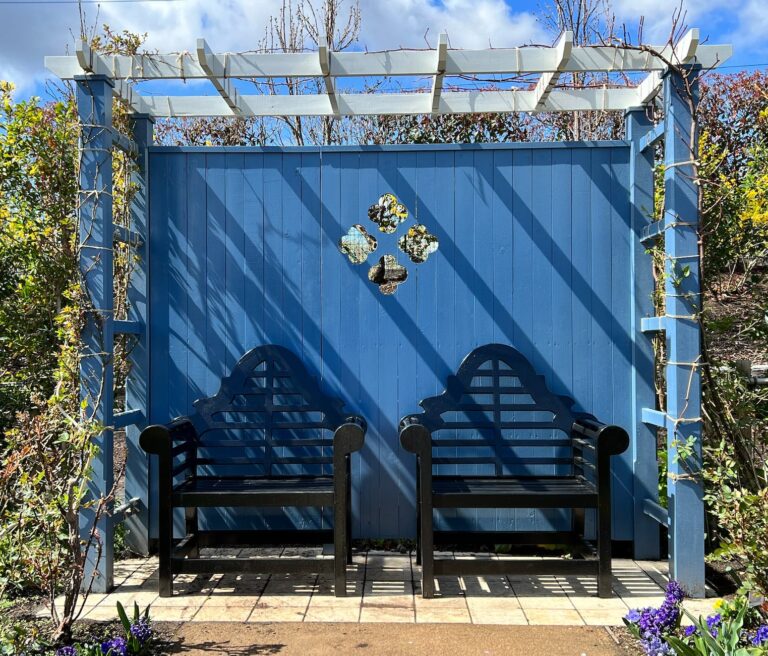 wooden chairs under blue pergola