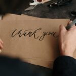 person writing on brown printer paper