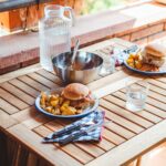 Outdoor table with plates of food on top.