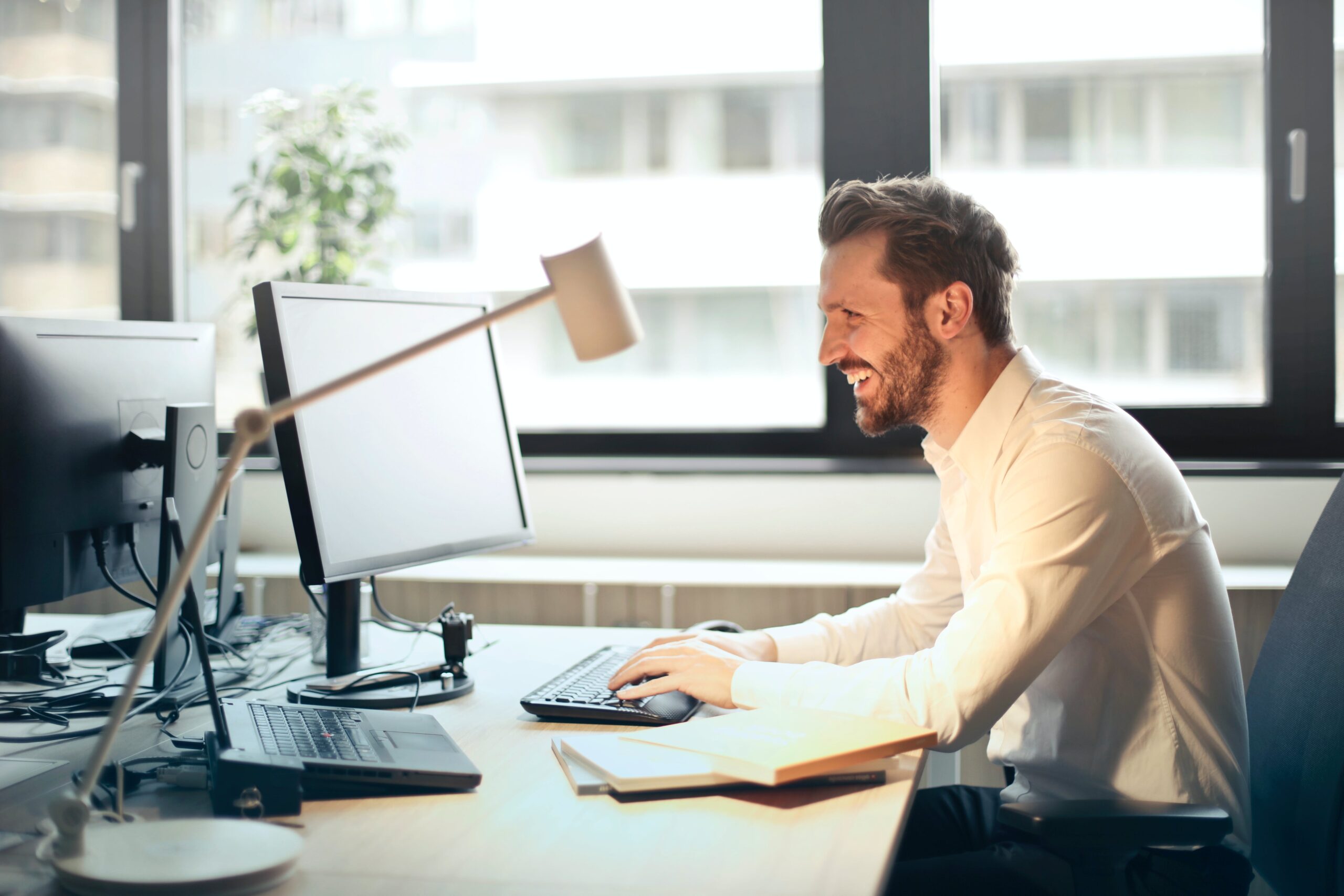 Business man sitting at a desk and looking at a computer.