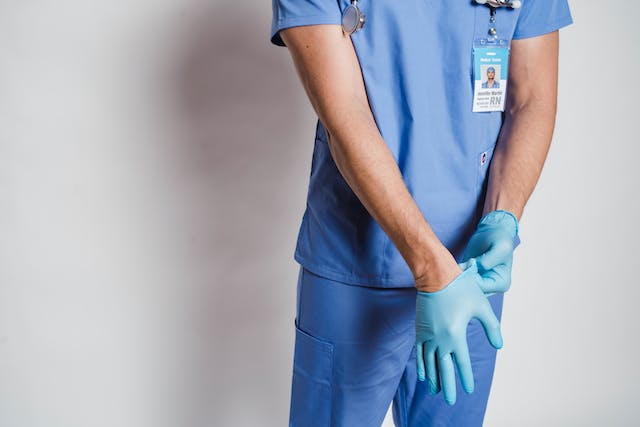 A medical assistant putting on gloves