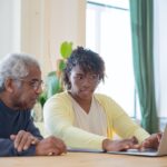 a man and a woman using a laptop together