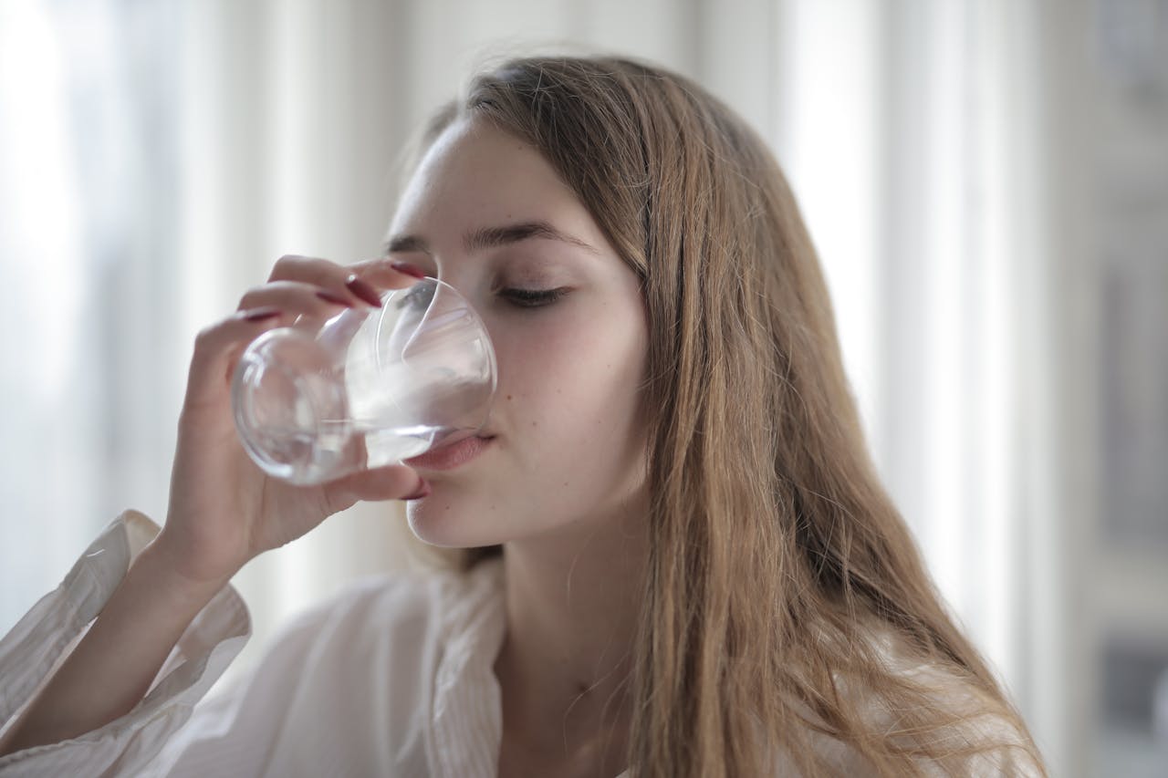 A woman drinking a glass of water.