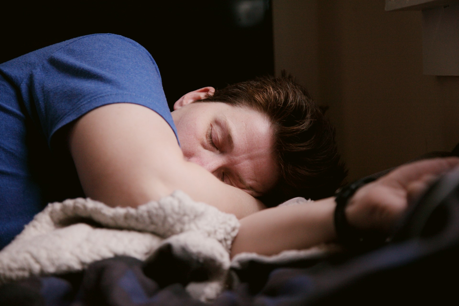 A tired-looking man lying on a couch.