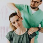 A woman having her neck adjusted by a chiropractor