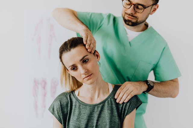 A woman having her neck adjusted by a chiropractor