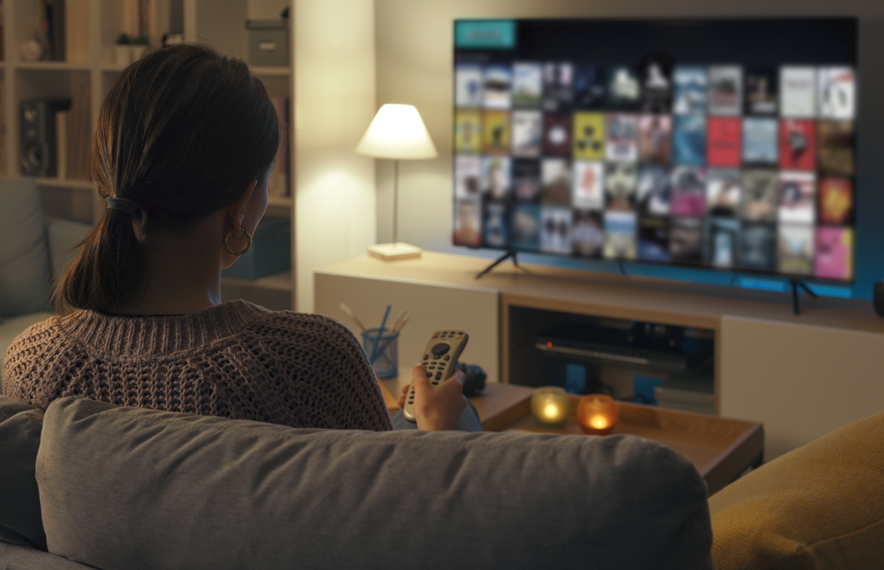 A woman watching TV alone in her home