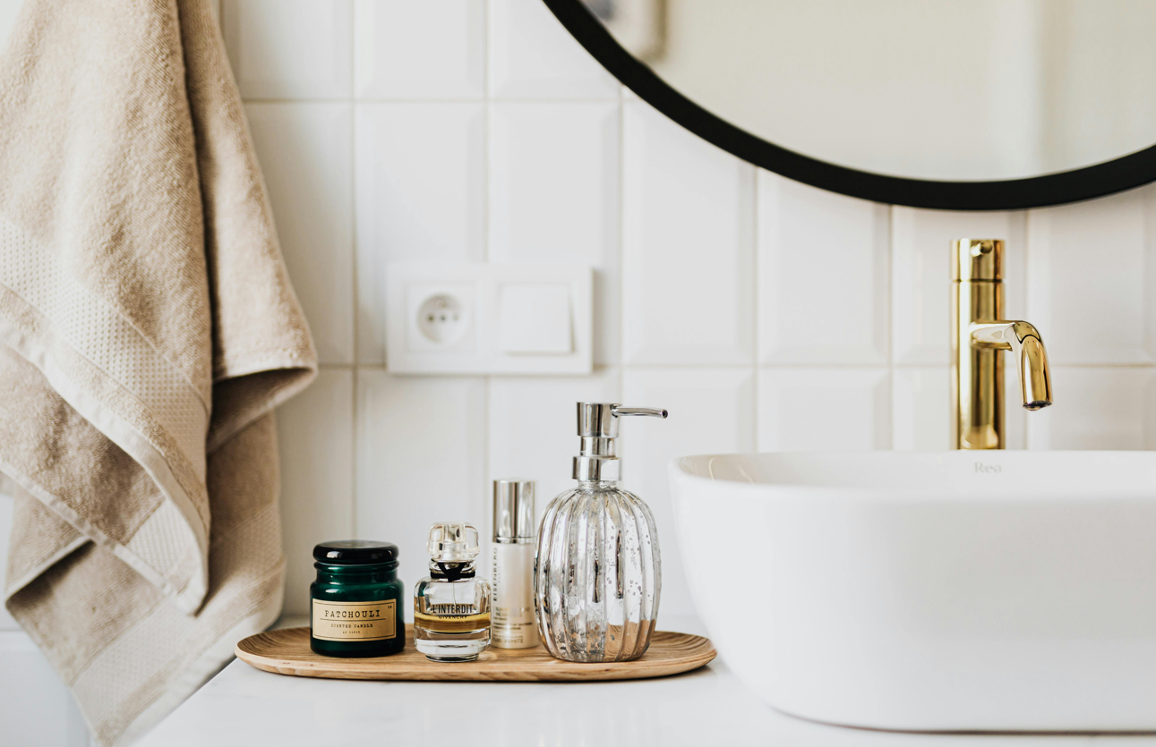 Bathroom countertop and sink with a range of toiletries.