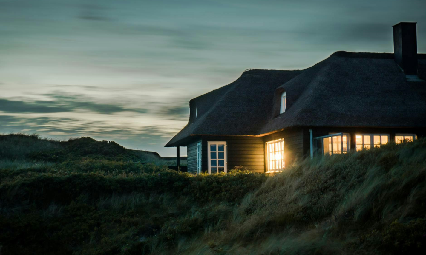 Illuminated house in the mountains before a storm.