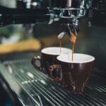 Photo of coffee dripping into a cup through a machine.