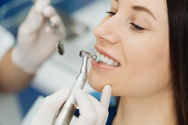 Lady's teeth being cleaned by a dental professional.