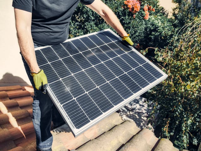 Person holding a solar panel