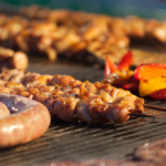 Barbeque, sausages, and other meat on a gas grill.