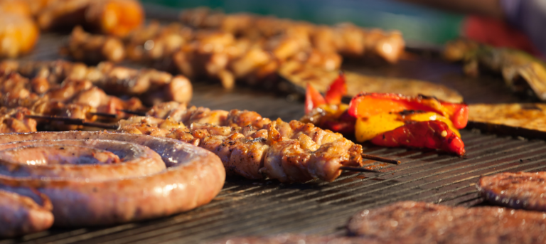 Barbeque, sausages, and other meat on a gas grill.