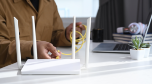 A hand plugging a wire to a router.