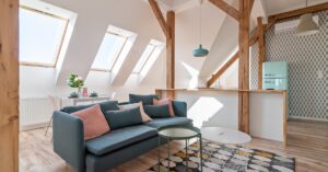 An updated attic with three skylights brightening the space with natural light, a small sitting area, and a kitchenette.