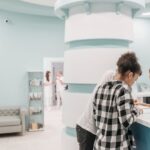 Couple reviewing documents at a medical center reception desk while staff assist.